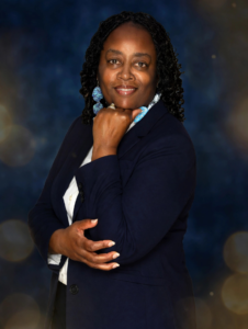 Blue blazer with hand under chin